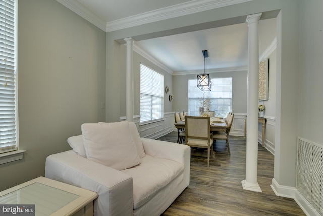 living area featuring dark hardwood / wood-style flooring, crown molding, and decorative columns