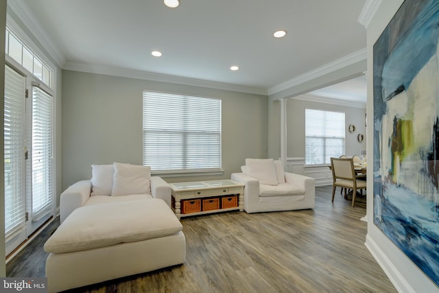 sitting room with hardwood / wood-style floors, ornamental molding, and ornate columns