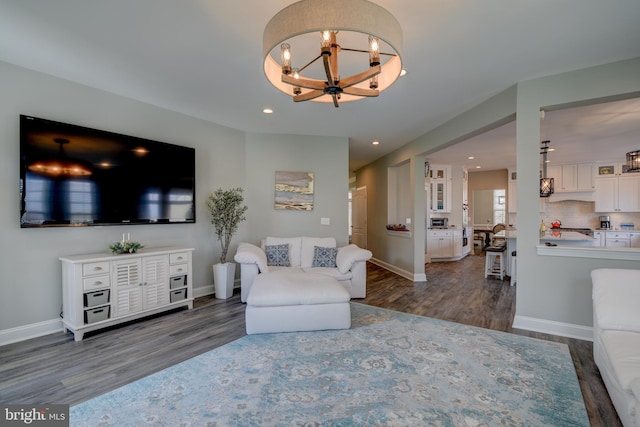 living room with a notable chandelier and dark wood-type flooring