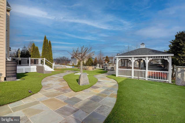 view of community with a gazebo, a wooden deck, and a lawn