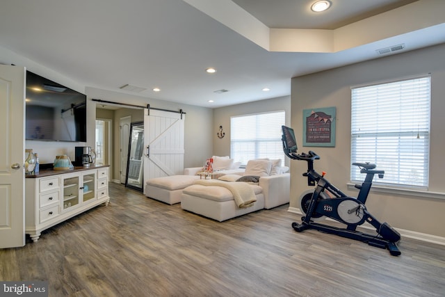 workout area with a barn door and hardwood / wood-style floors