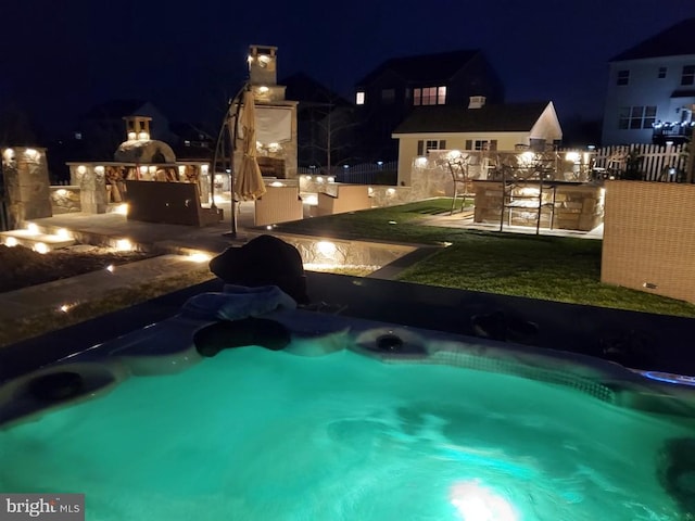 pool at night with exterior bar, exterior kitchen, and a patio