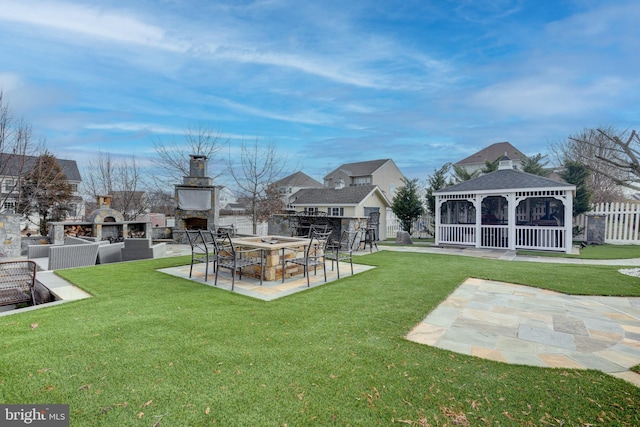 view of property's community with a gazebo, a patio area, and a lawn