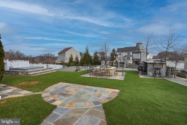 view of home's community featuring a yard, a bar, and a patio area