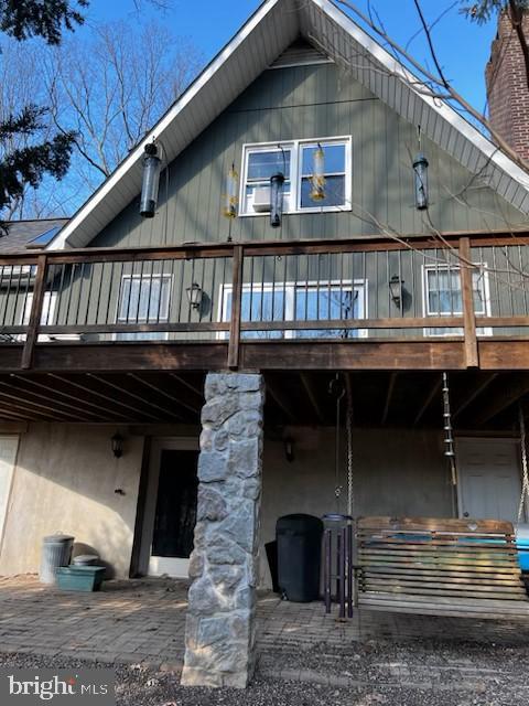 rear view of property with a chimney and a wooden deck