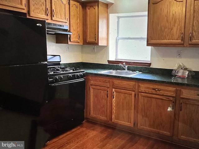 kitchen featuring sink, dark wood-type flooring, and black appliances