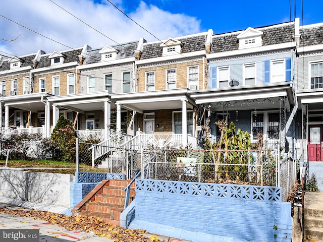 townhome / multi-family property featuring covered porch