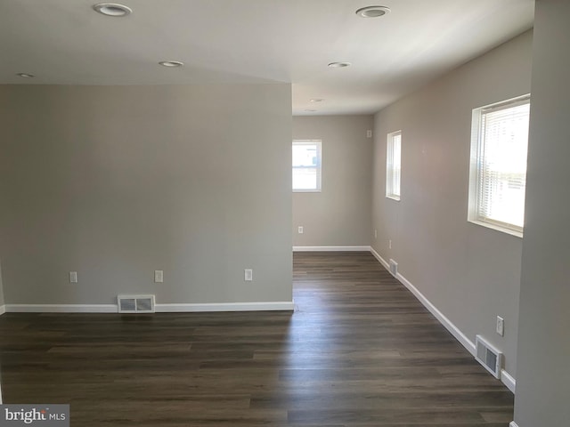 spare room with dark wood-type flooring