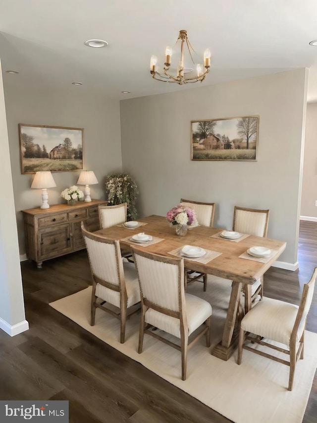 dining room with dark hardwood / wood-style flooring and a chandelier