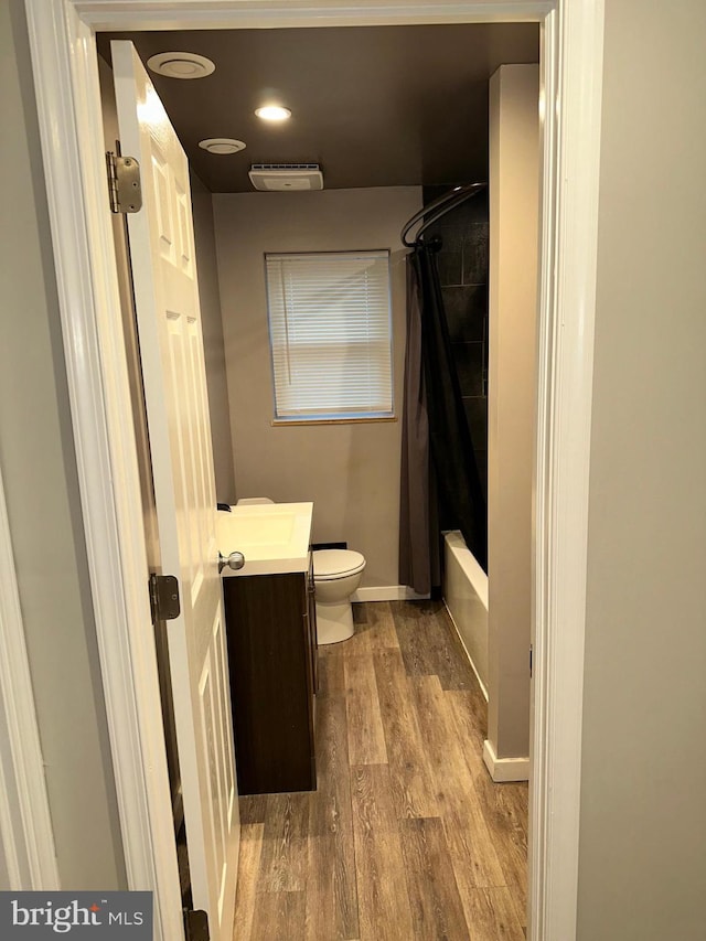 full bathroom with vanity, hardwood / wood-style floors, toilet, and shower / tub combo with curtain