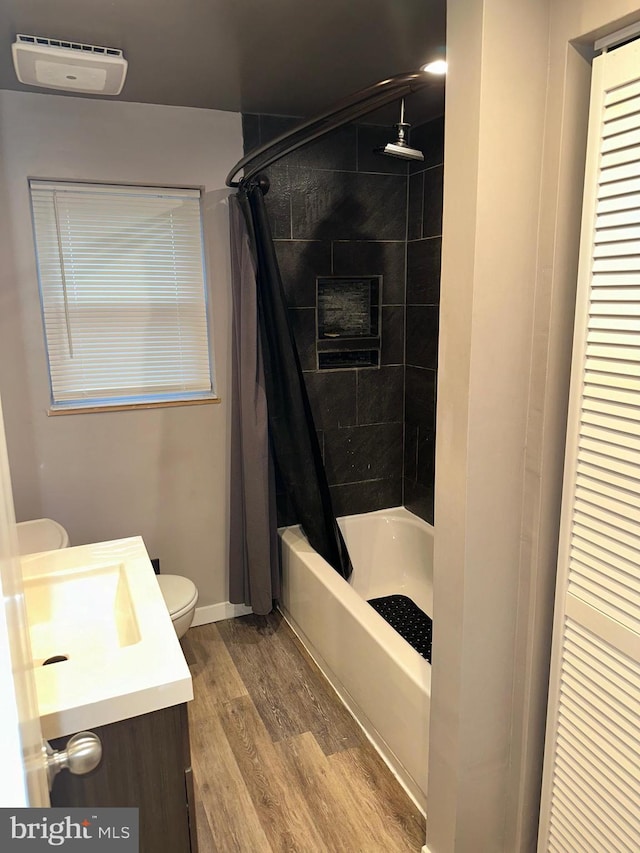 full bathroom featuring vanity, hardwood / wood-style floors, toilet, and shower / bath combo