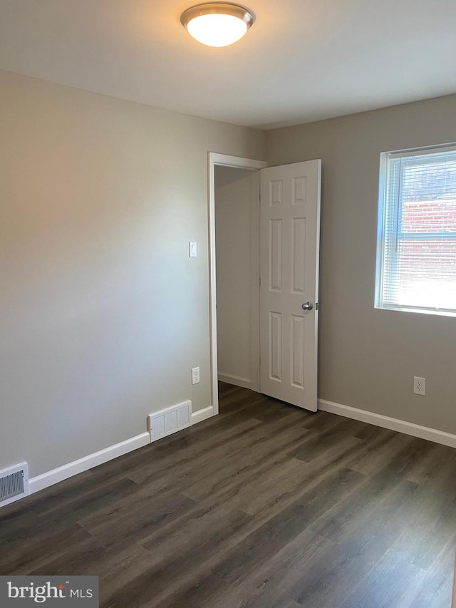 unfurnished room with dark hardwood / wood-style floors