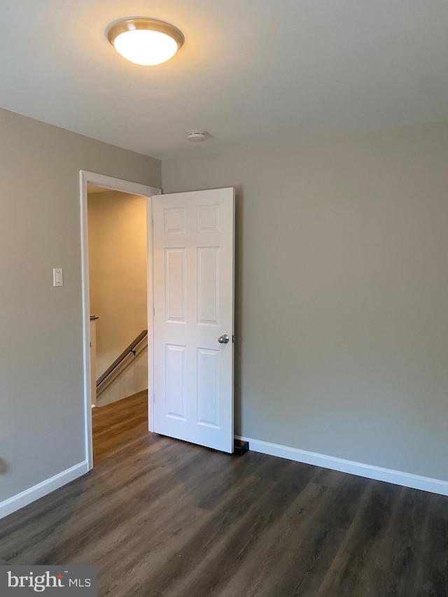 unfurnished room with a baseboard radiator and dark hardwood / wood-style floors