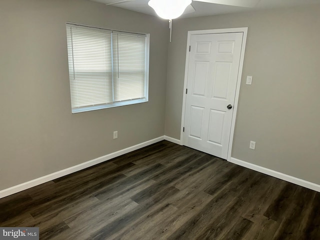 unfurnished room with dark wood-type flooring