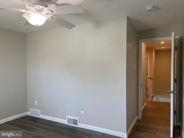 spare room with dark wood-type flooring and ceiling fan