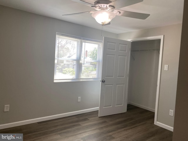 unfurnished bedroom featuring ceiling fan, dark hardwood / wood-style floors, and a closet