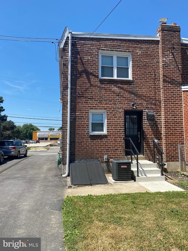 rear view of house with a yard and central air condition unit