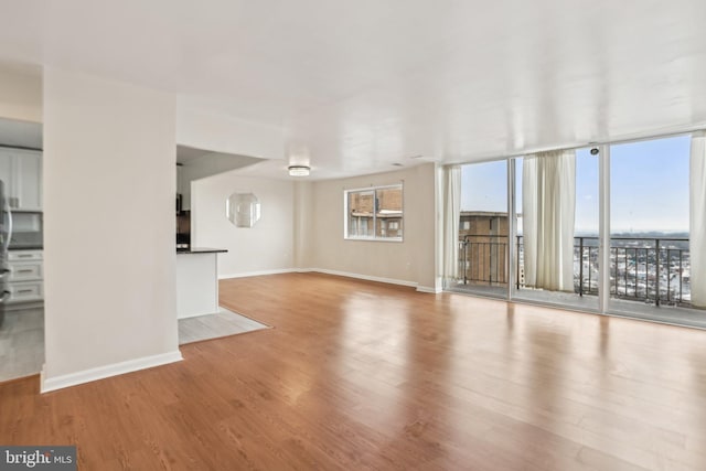 unfurnished living room with floor to ceiling windows and light hardwood / wood-style flooring