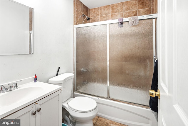 full bathroom featuring vanity, toilet, tile patterned floors, and bath / shower combo with glass door