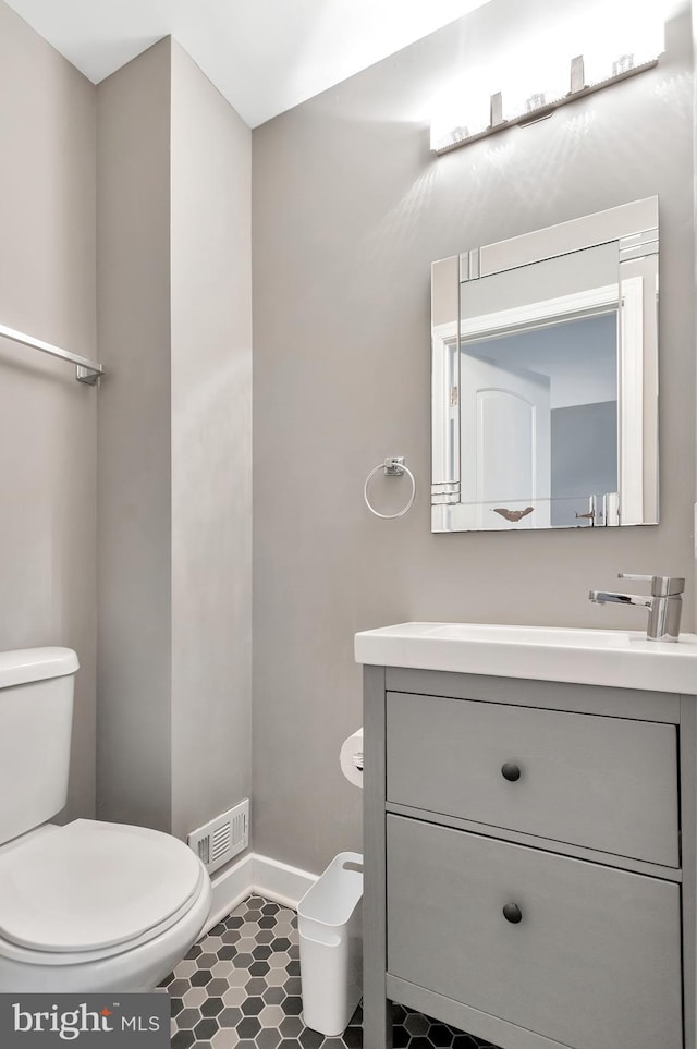 bathroom featuring vanity, toilet, and tile patterned flooring