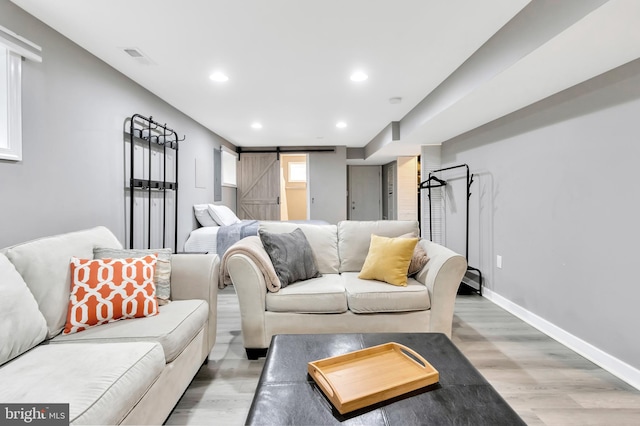 living room featuring wood-type flooring and a barn door