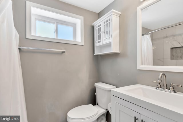 bathroom with vanity, toilet, and walk in shower