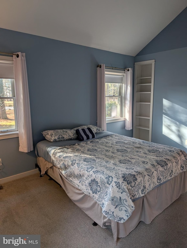 carpeted bedroom with lofted ceiling