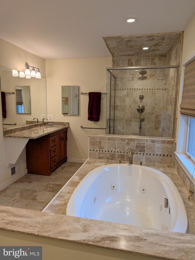 bathroom with vanity and shower with separate bathtub