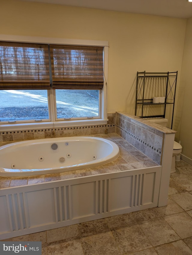 bathroom featuring a tub to relax in and toilet