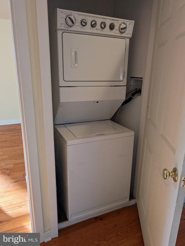 washroom with stacked washer / dryer and hardwood / wood-style floors