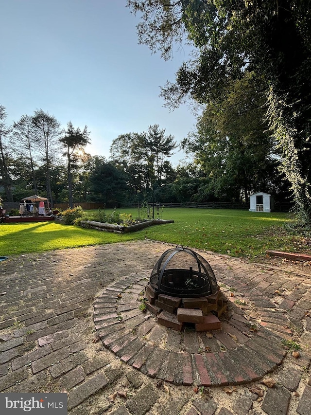 view of patio with a shed and a fire pit