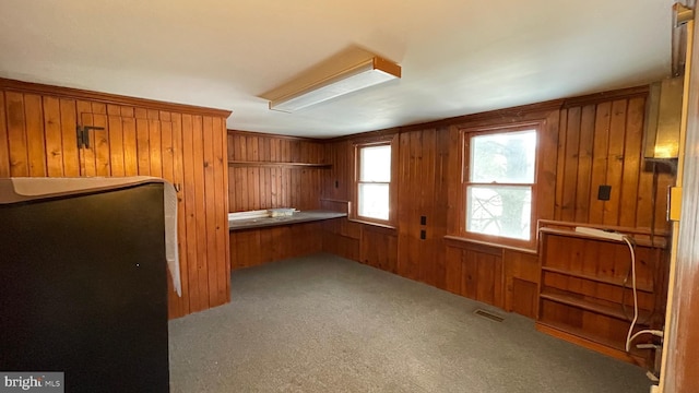 interior space with light carpet and wooden walls