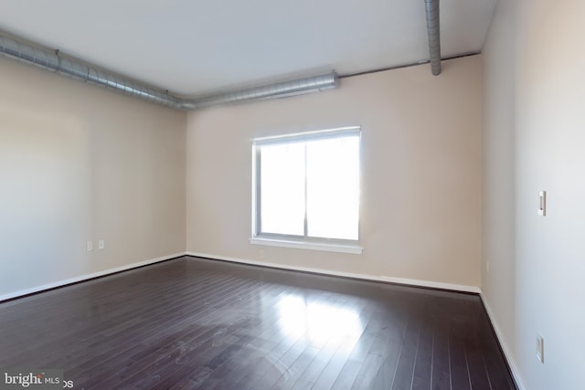 empty room with baseboards and wood finished floors