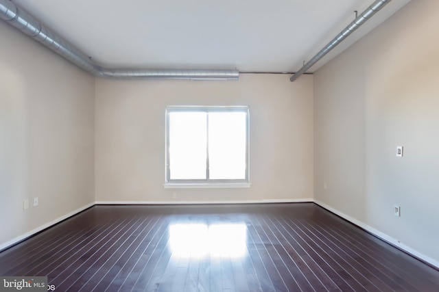 empty room featuring baseboards and wood finished floors