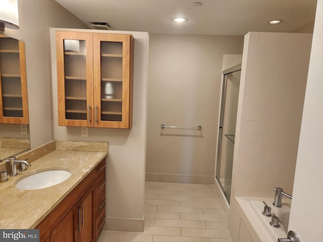 full bath with baseboards, tile patterned floors, vanity, a shower stall, and recessed lighting