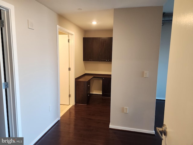 corridor featuring dark wood-style floors, baseboards, and recessed lighting