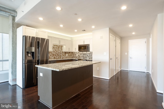 kitchen featuring stainless steel appliances, dark wood-style flooring, and a kitchen island