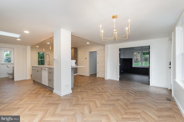 kitchen with an inviting chandelier, decorative light fixtures, light parquet floors, and white dishwasher