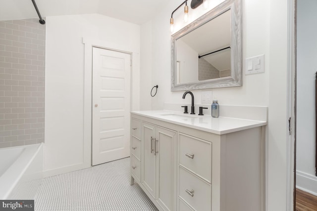 bathroom featuring tile patterned flooring, vanity, and tiled shower / bath