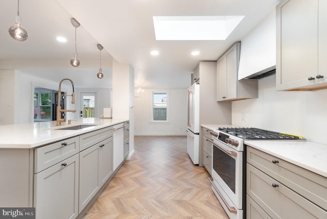 kitchen featuring sink, a skylight, pendant lighting, white appliances, and light parquet flooring