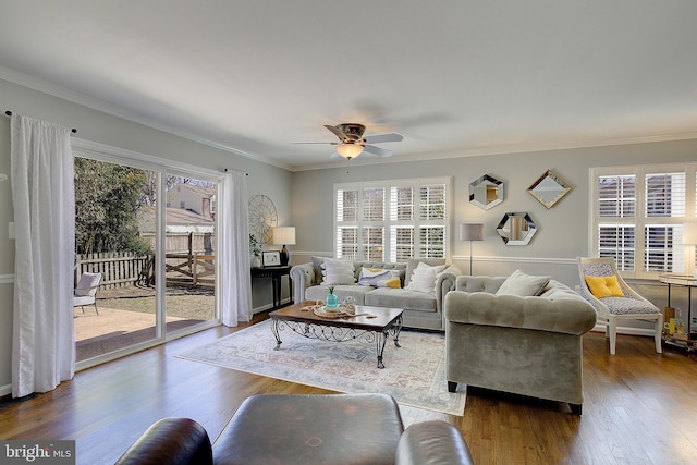 living area featuring a wealth of natural light, wood finished floors, a ceiling fan, and ornamental molding