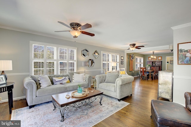 living room with ceiling fan, wood finished floors, baseboards, and ornamental molding