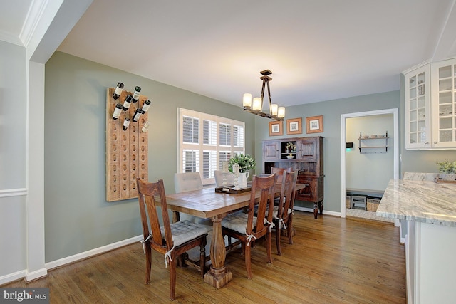 dining room featuring baseboards, light wood-type flooring, and an inviting chandelier