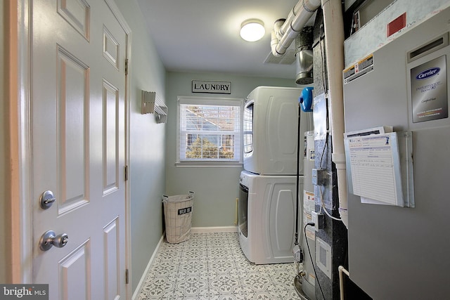 clothes washing area with laundry area, stacked washer / dryer, heating unit, and baseboards