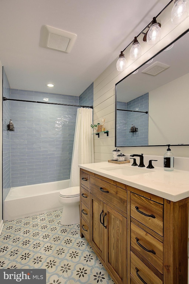 bathroom featuring vanity, toilet, shower / bath combo, and visible vents