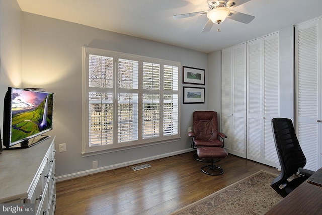 home office with visible vents, ceiling fan, baseboards, and wood finished floors