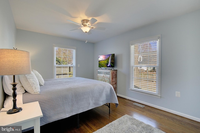 bedroom featuring visible vents, baseboards, wood finished floors, and a ceiling fan