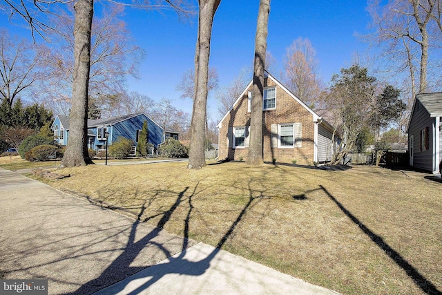 view of front of home featuring brick siding and a front yard