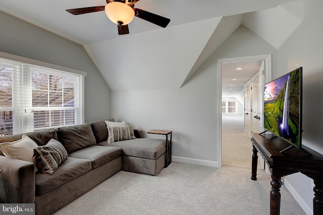 carpeted living area with lofted ceiling, baseboards, and ceiling fan