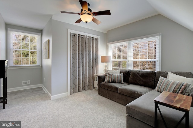 living area featuring visible vents, ceiling fan, baseboards, vaulted ceiling, and carpet floors